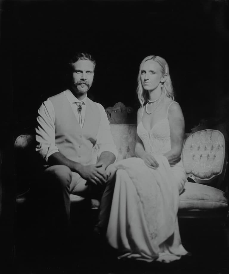 Studio tintype of a couple seated against a black backdrop