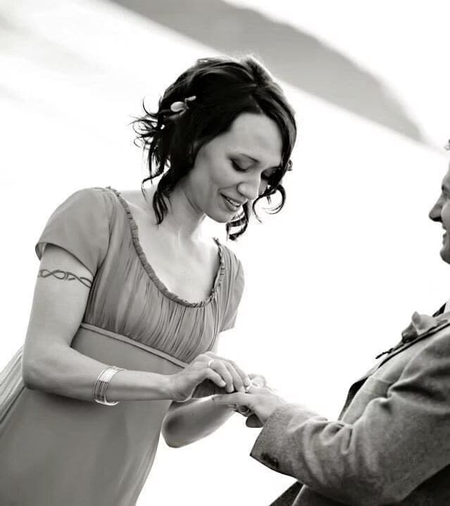 Bride with pinned curls exchanging rings in black and white