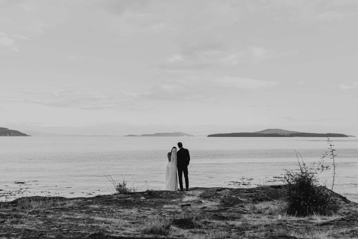 Couple overlooking distant Gulf Islands from a bluff in monochrome