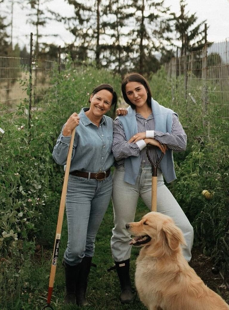 Whiffle and Hum farmers posing with their golden retriever between flower rows