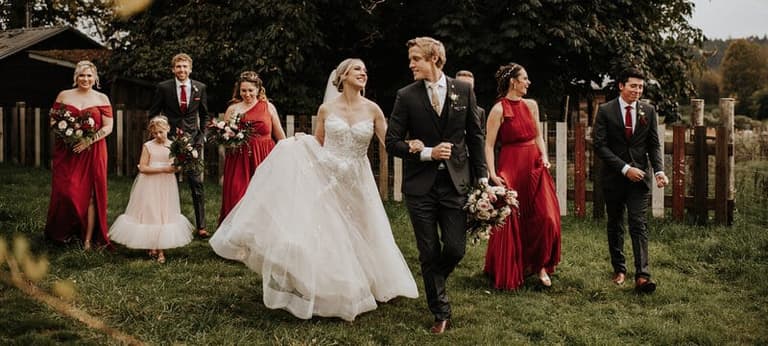 Wedding party in deep red strolling the grounds of Keating Farm