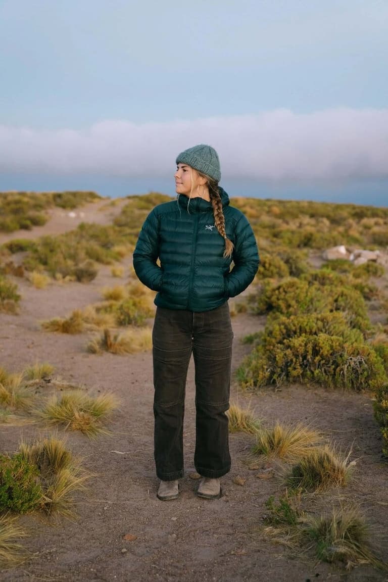 KR Photo's photographer in a teal puffer among windswept dunes