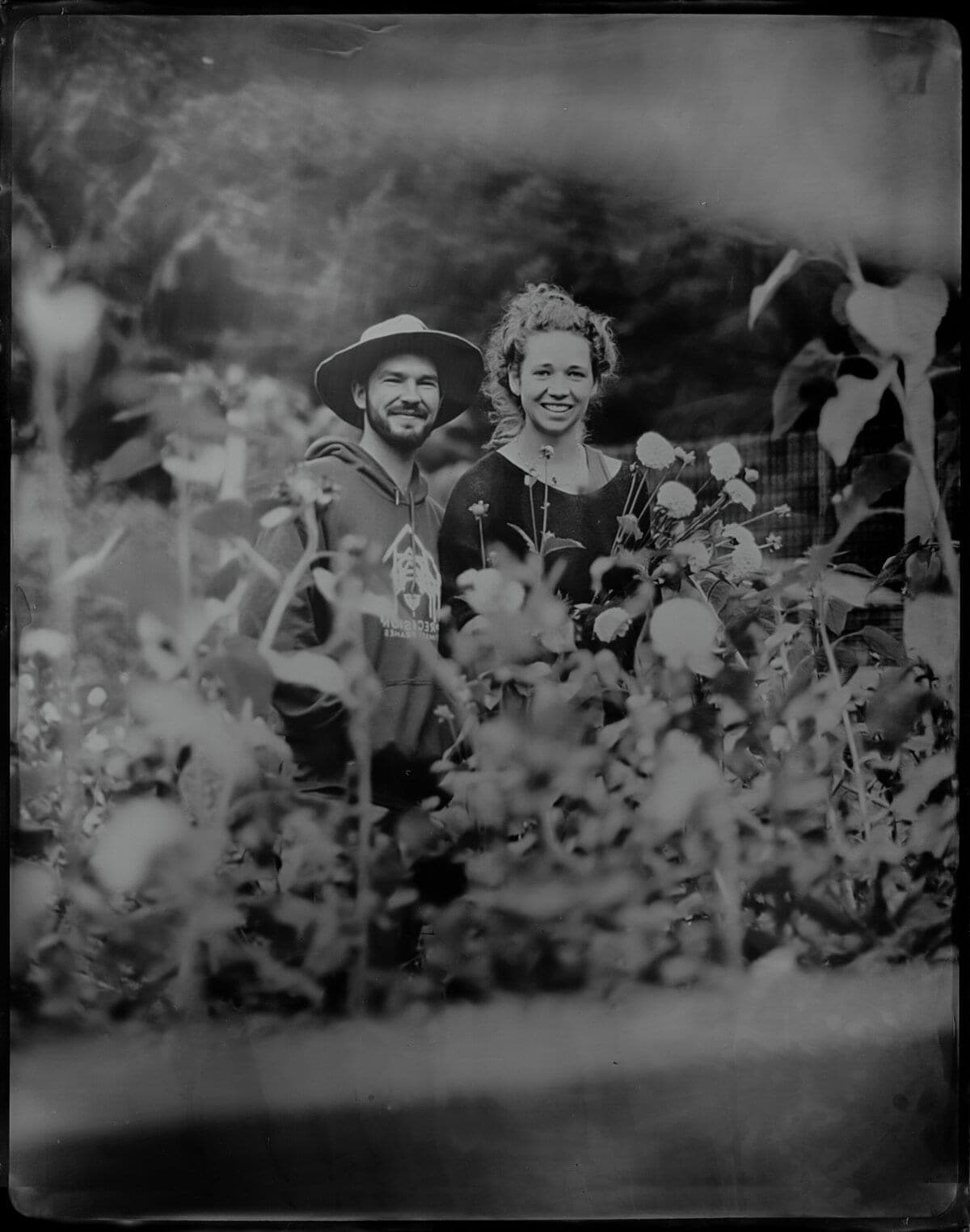 Tintype portrait of a couple framed by garden flowers