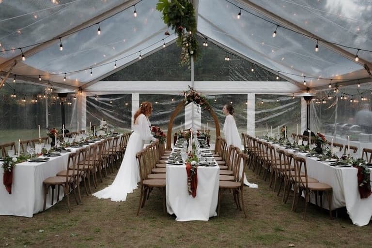 Long white tables under a clear-top tent from Black & White