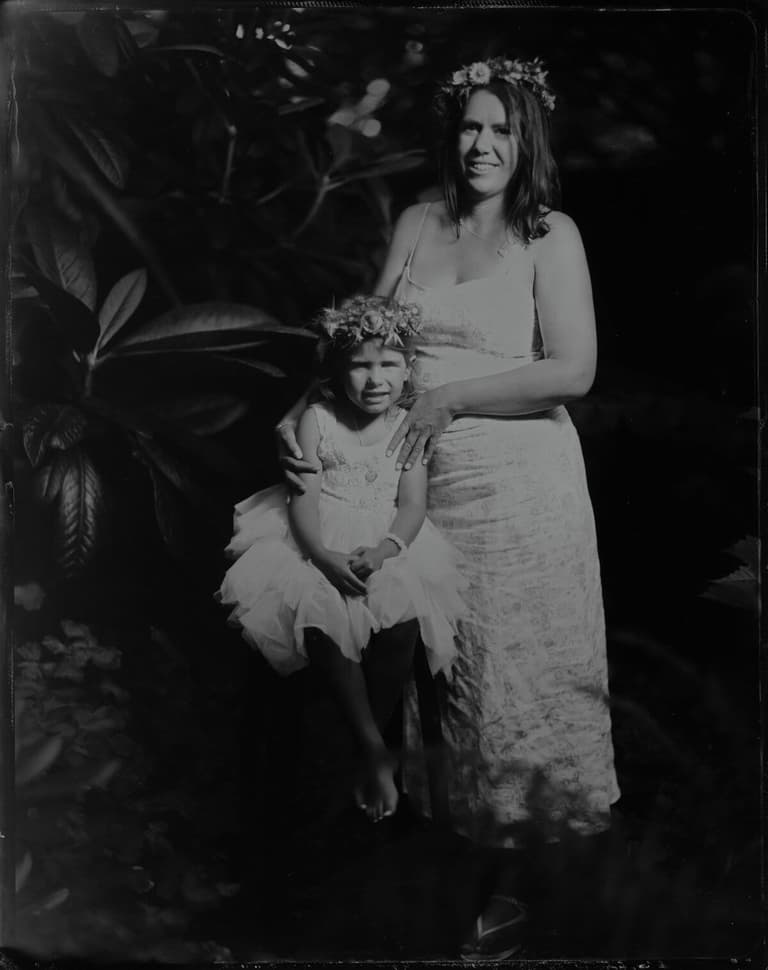 Flower-crowned mother with a little girl in a tulle dress