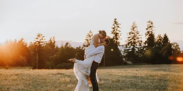 Groom lifting his bride at sunset in a Shannon Farms field