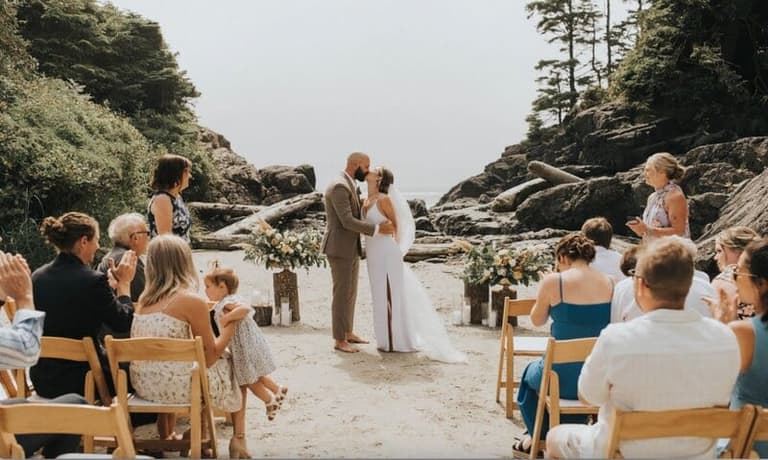 Newlyweds embrace in cox cove in Tofino