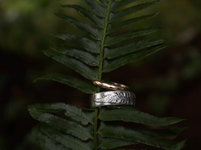 Wedding bands sitting on fern